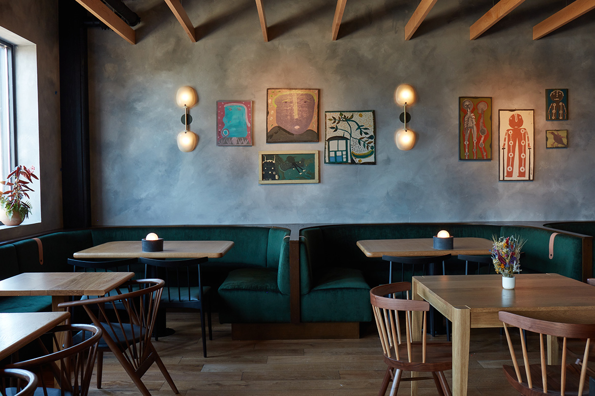 Interior shot of Audrey Restaurant in Nashville with velvet booths and artwork on the wall